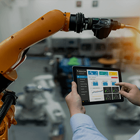A Man Using A Tablet To Control Machinery In Engineering Industry