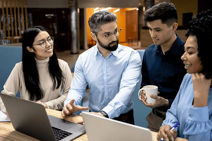 A Men Explaining To Collogues Using Laptop